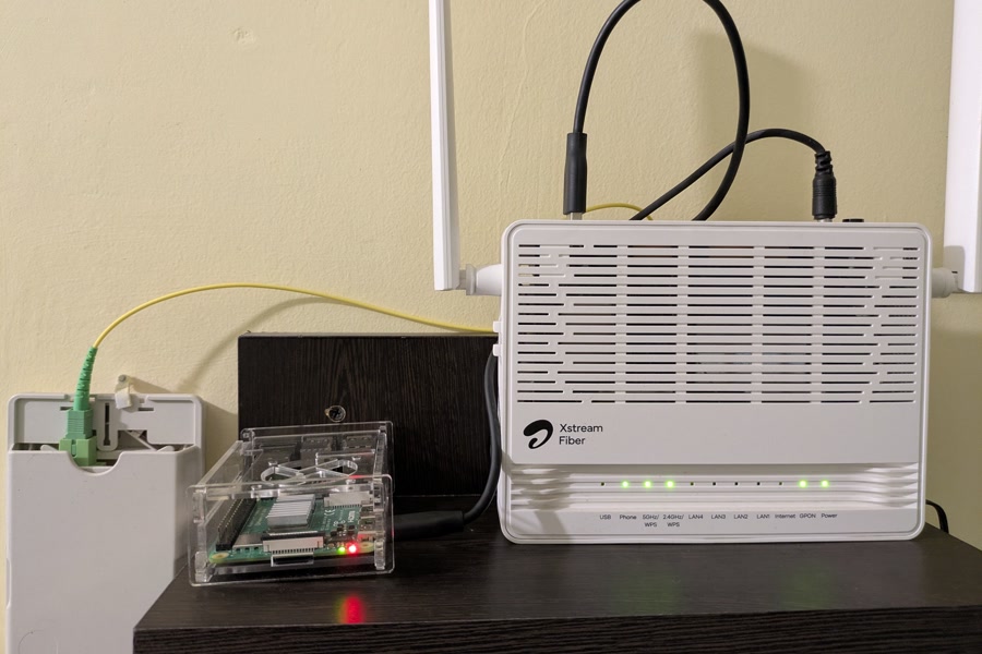 A Raspberry Pi in a clear case next to a fibre router